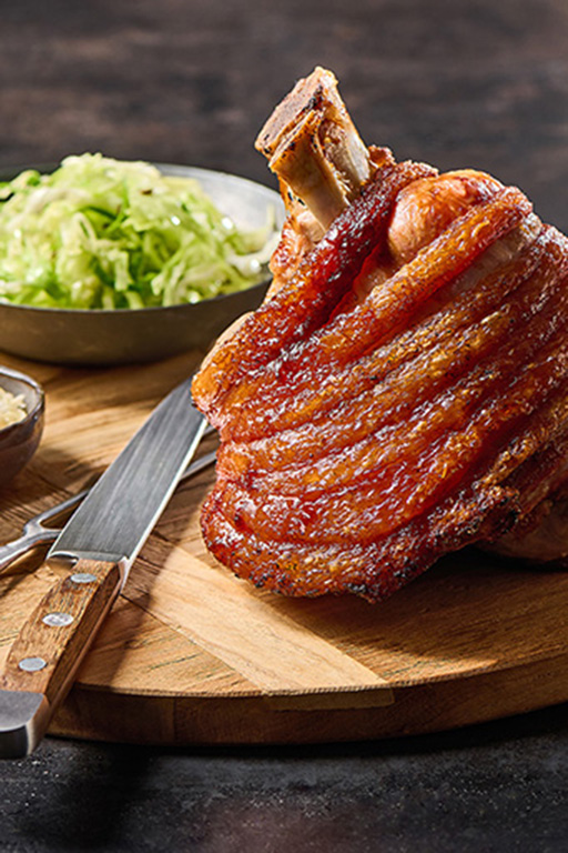 Knusprige Schweinestelze auf Holzbrett