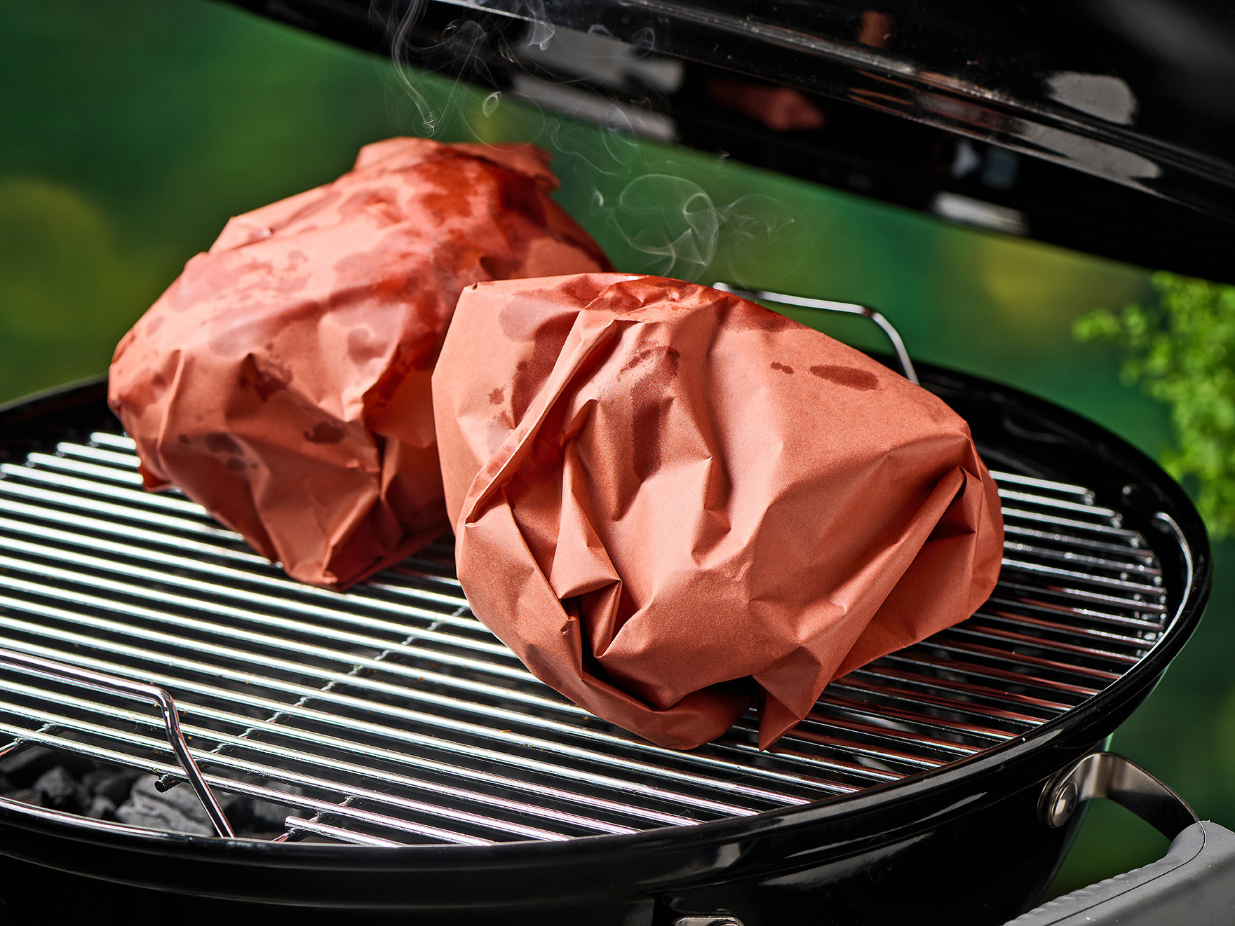 Schweinestelze in Papier auf Grill