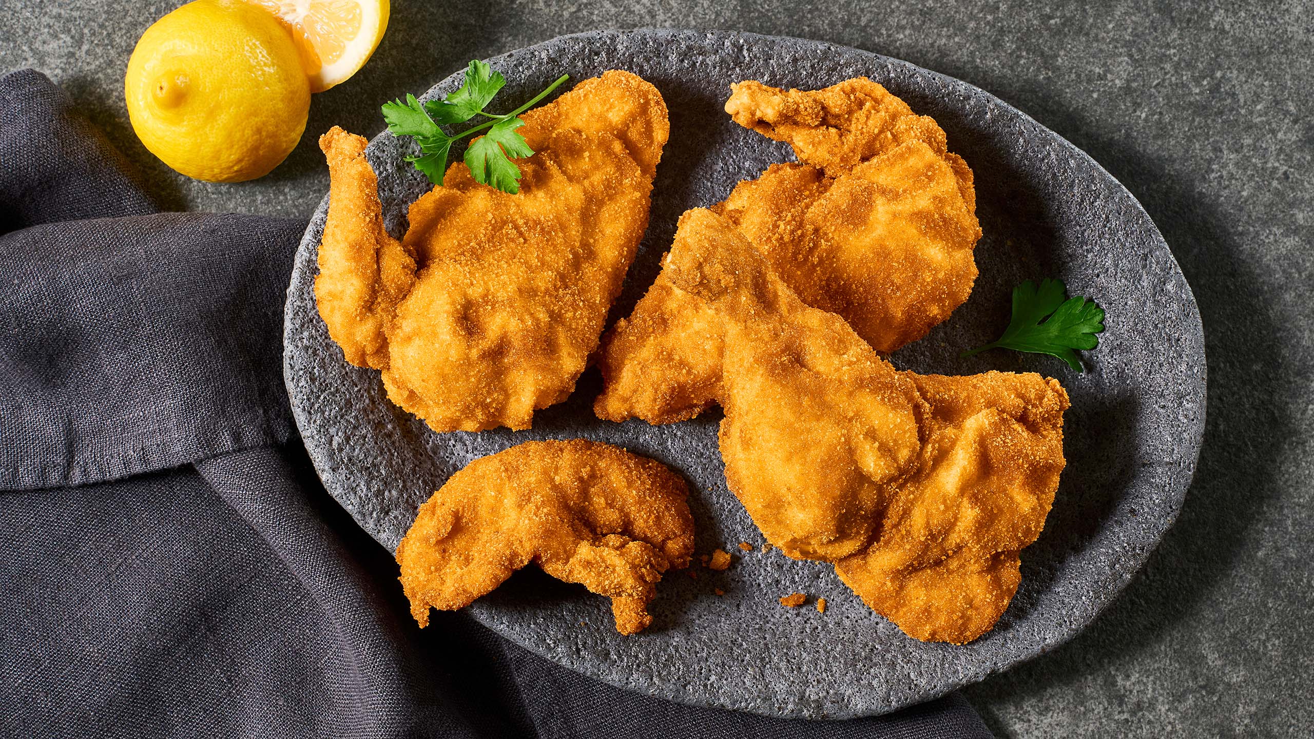 Backhendl angerichtet auf einem schwarzen Teller