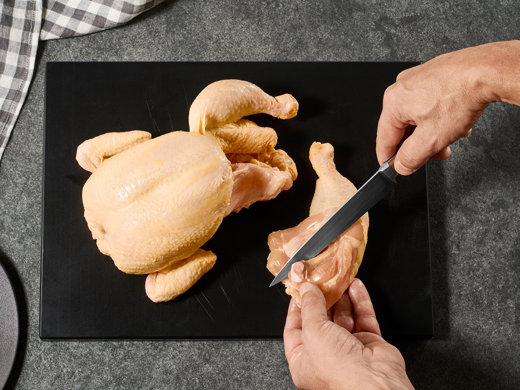 Backhendl vorbereiten: Keule wird abgetrennt und geschnitten